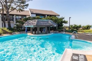 A pool with a bar and a gazebo in the background.