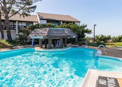 A pool with a bar and a gazebo in the background.