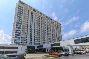 A large white building with cars parked in front of it.