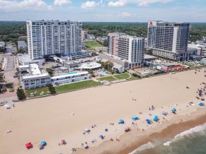 A beach with many people on it and some buildings