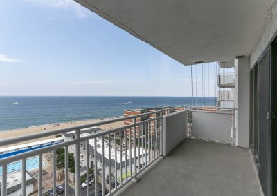 A balcony with a view of the ocean and beach.