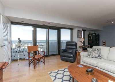 A living room with a couch, chair and television.