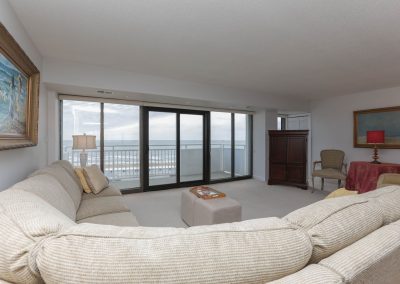 A living room with large windows and a couch