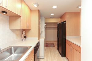 A kitchen with wooden cabinets and black appliances.