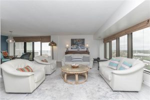 A living room with white furniture and a fireplace.