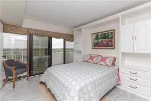 A bed room with a large window and a balcony