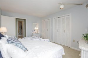 A bedroom with white walls and a large bed.