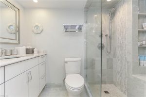 A bathroom with white cabinets and a toilet