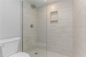 A bathroom with a walk in shower and tiled walls.