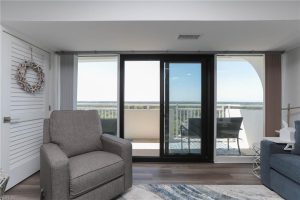 A living room with sliding glass doors and a view of the ocean.