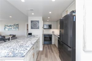 A kitchen with white cabinets and black appliances.