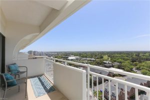 A balcony with a view of the city and trees.