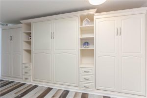 A white wall unit with many drawers and shelves.