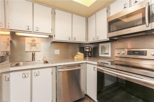 A kitchen with white cabinets and stainless steel appliances.