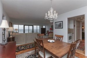 A dining room table with chairs and a chandelier.