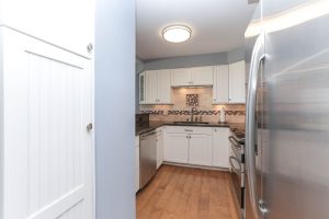 A kitchen with white cabinets and stainless steel appliances.