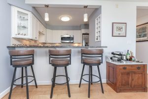 A kitchen with three stools and a counter