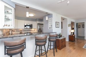 A kitchen with a bar and stools in it