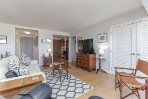 A living room with a couch, chair and television.