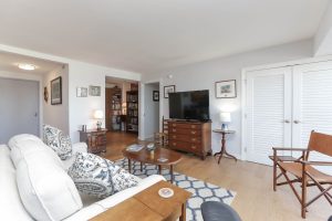 A living room with a couch, table and television.