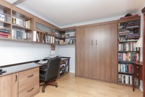 A desk and chair in the corner of a room.