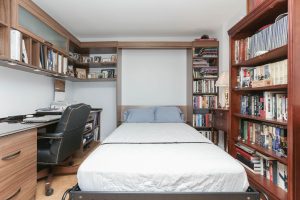 A bed with white sheets and blue pillows