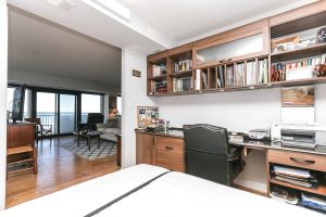 A bedroom with a desk and chair in it