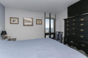 A bedroom with a large bed and dresser in it