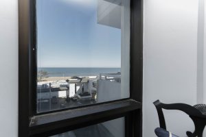 A view of the ocean from an open window.