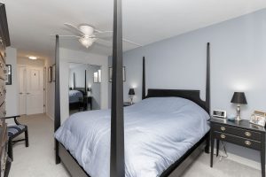 A bedroom with four poster bed and blue walls.