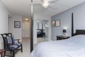 A bedroom with a bed, chair and table.