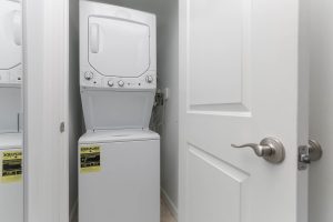 A white washer and dryer in the corner of a room.