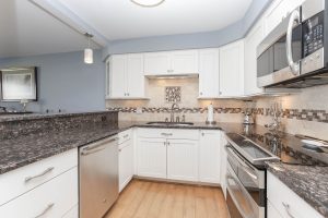 A kitchen with white cabinets and stainless steel appliances.