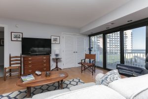 A living room with a couch, television and sliding glass doors.