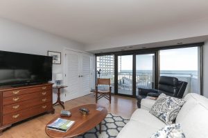 A living room with a couch, television and a table.