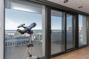 A telescope is on the floor of an apartment.