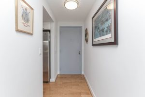 A hallway with a door open and a light on.