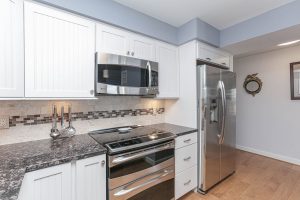 A kitchen with white cabinets and stainless steel appliances.