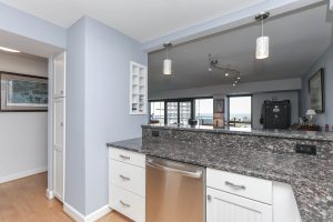 A kitchen with white cabinets and granite counter tops.